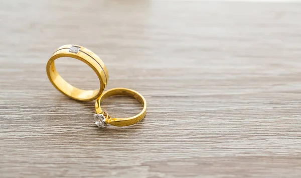 gold wedding rings on a wooden background