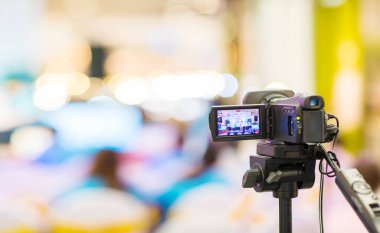 profesyonel fotoğrafçı arka planı bulanık video kamerayı çekiyor.