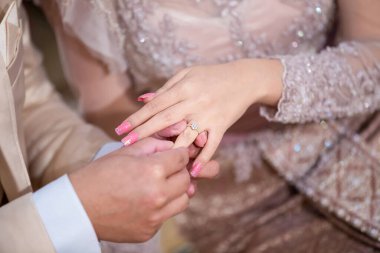 Gelin ve damat el ele tutuşuyorlar.