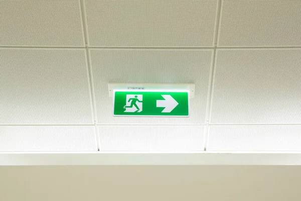 green emergency exit sign with a white background