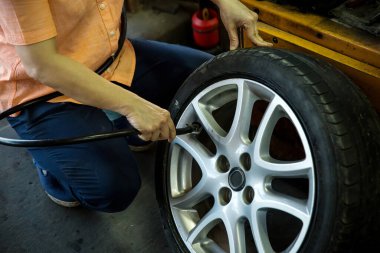 mechanic repairing car wheel, closeup