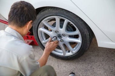 man changing wheel with car tire clipart