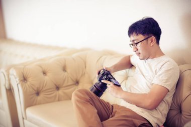 young man playing video game on sofa