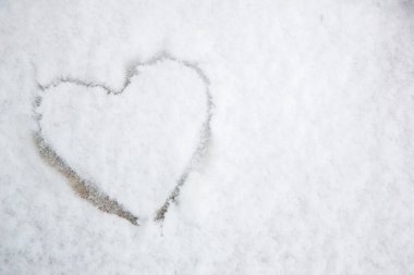 Karlı bir kış gününün arka planında kar şeklinde bir kalp.