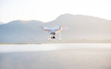 Dron dağlarda tripodun üzerinde uçuyor.