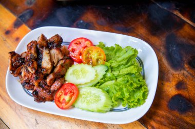 Izgara domuz pirzolası, sebze ve sos.