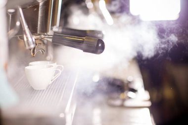 Kahve makinesi ve bir fincan sıcak çay.