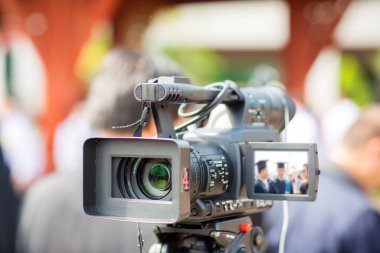 Profesyonel fotoğrafçı mikrofonla video kamera kaydediyor.