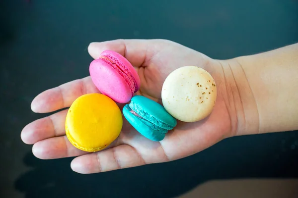Colorful Macaroons Hand Blue Background — Stockfoto