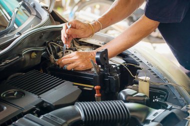 mechanic repairing car engine in garage