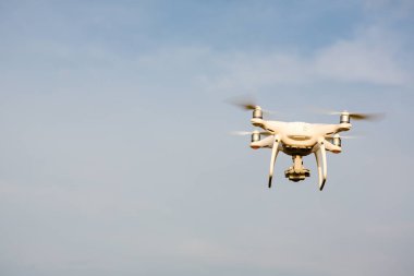 Gökyüzünün arka planında uçan insansız hava aracı.