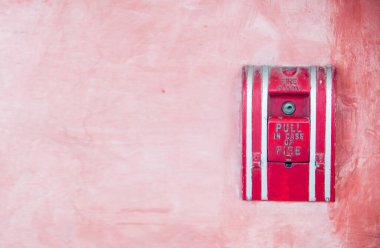 Duvarda kırmızı yangın musluğu var.