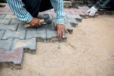 İşçi mala ve beton zemin ile çalışıyor.