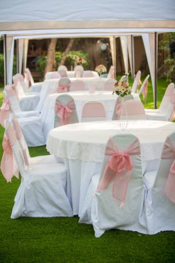 Beyaz sandalyeli ve çiçekli düğün masası