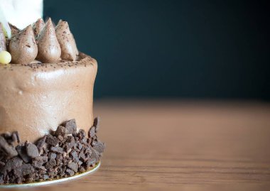 Vanilya kremalı çikolatalı pasta ve ahşap arka planda fındık..