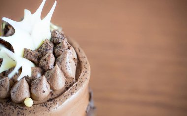 Çırpılmış kremalı çikolatalı pasta ve tahta arka planda kakao..