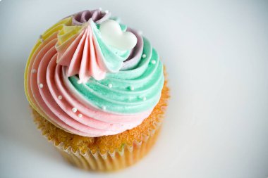 Kremalı lezzetli kek ve beyaz arka planda renkli krema.