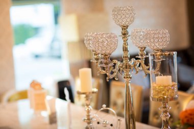 Mumlar ve çiçeklerle düğün masası.