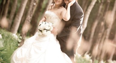 Gelin ve damat bir buket çiçekle gelinlik giyer.