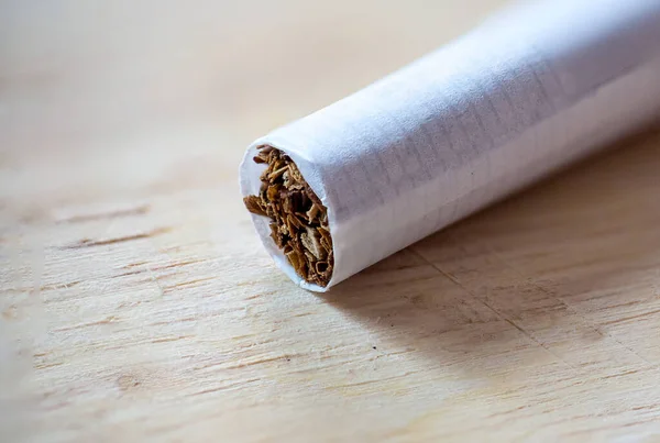 tobacco pipe with a cigarette on a wooden background