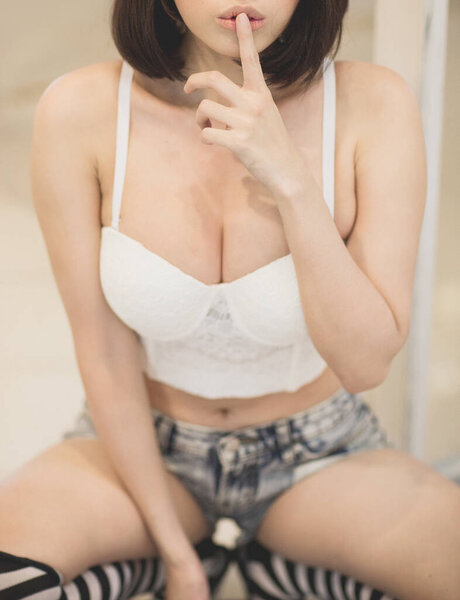красивая молодая женщина в черном белье и белые трусики на губах