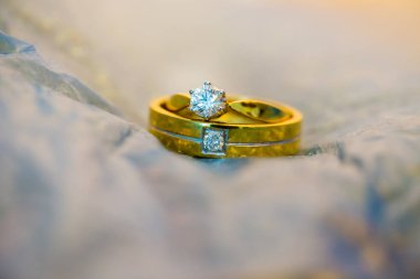 Beyaz arkaplanda elmas yüzükler olan altın bir yüzük.