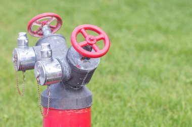 Suyun arka planında kırmızı vana ve benzin pompası var.