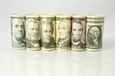 Bir sürü dolar. Amerikan dolarları banknotları. Beyaz arka planda izole edilmiş çeşitli para birimlerinin yığını. Çeşitli Amerikan bankalarının kapatılması. Masaya saçılmış Amerikan para birimi..