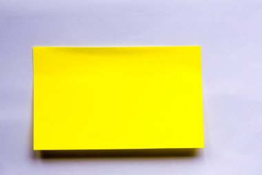 Yapışkan not ahşap arka planda izole edilmiş. Eski bir not kağıdının kapağı. Vintage sarı kağıt. Yapıştırıcı notu beyaz arkaplanda izole edilmiş..