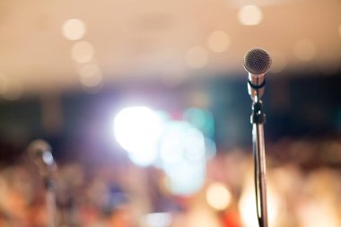 Konser salonundaki ya da konferans salonundaki mikrofon arka plan için yumuşak ve bulanık. Mikrofon konferans salonunun ya da seminer salonunun bulanık fotoğrafı üzerinde..