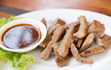 Dilimlenmiş biftek ve yeşil yapraklı salata. Kırsal tabaklarda salata. Orta pişmiş ızgara biftek ve gri taşlı arka planda sağlıklı salata.