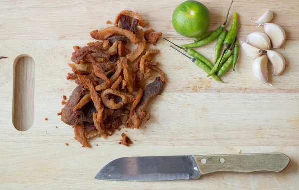油炸猪肉洗净或刮擦是受欢迎的小吃 生猪肉和芦笋 炸猪肉 脆炸猪肉 干猪肉厨房木板上的一堆花纹 — 图库照片