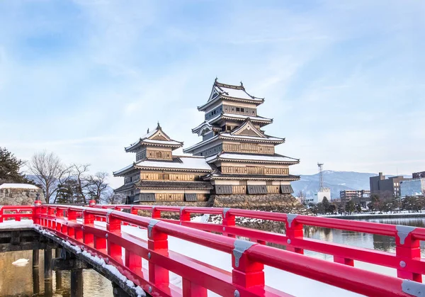 Old castle in japan. Matsumoto castle against blue sky in Nagono city,Japan. Castle in Winter with heavy snowfall. Travel Matsumoto Castle with frozen pond in Winter. Japanese and East Asian Civilization