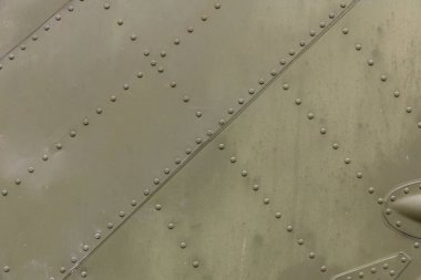 Perçinli uçak gövdesinin eski gümüş metal yüzeyi. Demir plaka, çelik levha doku, desen ve arka plan. Uçak gövdesinin alüminyum yüzeyi. Düzgün perçin satırları.