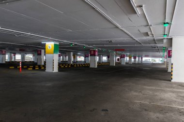 Öğleden sonra içi boş uzay parkı. Kapalı otopark. Otoparkın içinde, içinde araba ve boş otopark var. Daire ya da mağazada boş bir otopark..