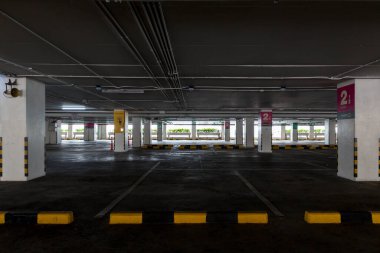 Öğleden sonra içi boş uzay parkı. Kapalı otopark. Otoparkın içinde, içinde araba ve boş otopark var. Daire ya da mağazada boş bir otopark..