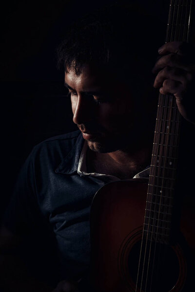 man with a guitar on a black background