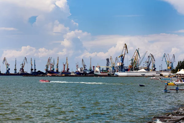 Cargo ship at Trade Port harbor with crane and blue sky over sea at sunrise — Stock Photo, Image