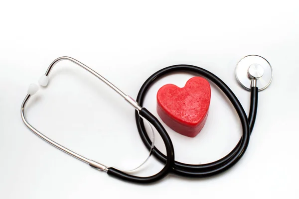 Inima roșie și un stetoscop pe birou — Fotografie, imagine de stoc