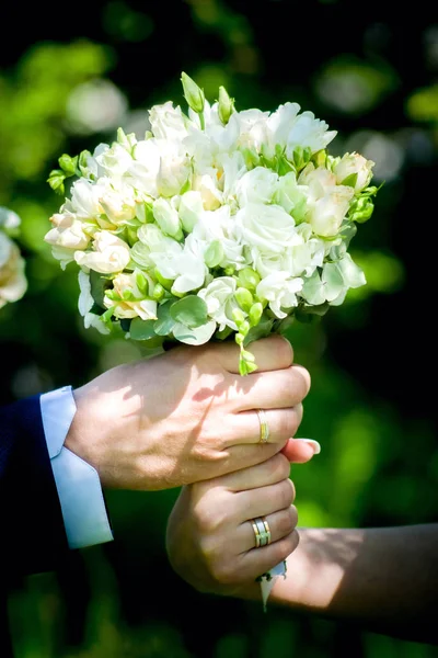 Matrimonio. Arredamento. Scarpe da sposa, un bellissimo bouquet da sposa, anelli, boutonniere e gioielli sono splendidamente disposti su uno sfondo di legno grigio . — Foto Stock