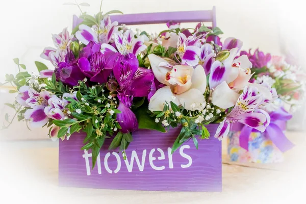 Florista en el trabajo: mujer rubia bastante joven haciendo ramo moderno de moda de diferentes flores — Foto de Stock