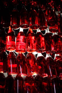 Duvarda iç mekan olarak asılı bir sürü şişe var.