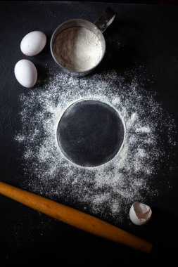 Un, siyah beton bir arka planda daire şeklinde püskürtülür. Bir yazı için fotoğraf.