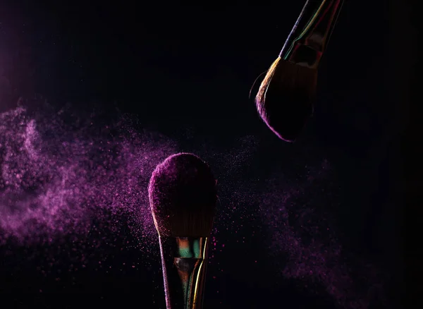 İmaj sanatı. İki profesyonel siyah makyaj fırçasının yakın plan fotoğrafı. Siyah arkaplanda mor toz ve fotokopi yeri var.. 