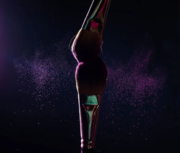 İmaj sanatı. İki profesyonel siyah makyaj fırçasının yakın plan fotoğrafı. Siyah arkaplanda mor toz ve fotokopi yeri var.. 