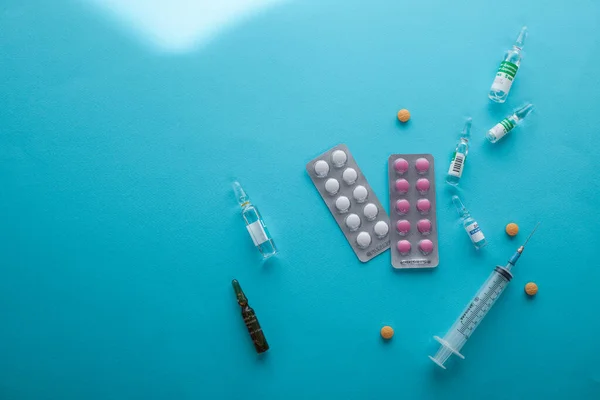 Soyut bir arka planda renkli vitamin hapları, kapsüller ve ilaç ampulleri. Sağlık, medikal ve eczacılık konsepti. Ayrıntılı olarak kopya alanı ile yakın çekim stüdyosu. 