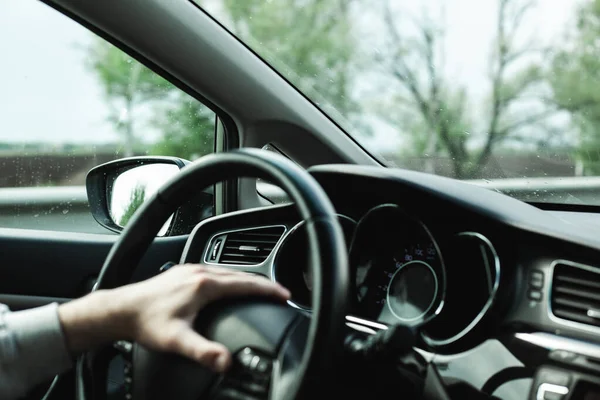 Adam araba kullanıyor. Arabanın penceresinden güzel bir doğa..