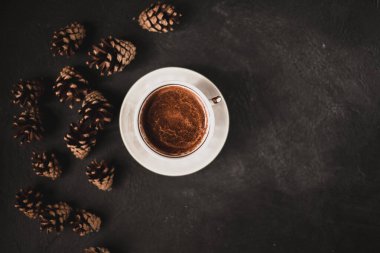 Bir fincan kahve ve külahlar koyu bir arka plana saçılmış. Metnin için fotokopi alanı olan üst manzara.