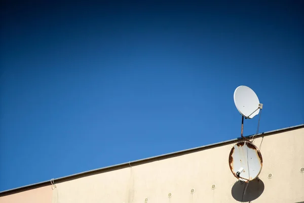 Round satellite dishes are receivers of electromagnetic waves transmitted by various television networks.