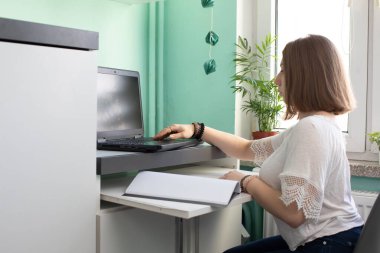 Lise diplomasından hemen önce evde kalma emri sırasında uzak mesafe öğrenimi. İnternette yaşamayı öğrenme maksadıyla dizüstü bilgisayarın önünde oturan bir genç..